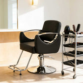 Black salon chair with a cart of tools in a well-lit room