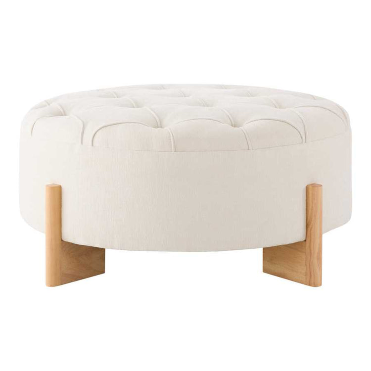 Round ottoman with tufted white cushion and wooden legs on a white background