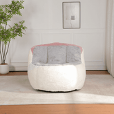Modern white and gray chair with pink accents in a room with a plant and framed picture on the wall.