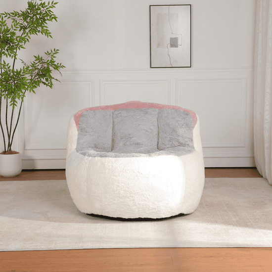 Modern white and gray chair with pink accents in a room with a plant and framed picture on the wall.