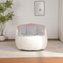 Modern white and gray chair with pink accents in a room with a plant and framed picture on the wall.