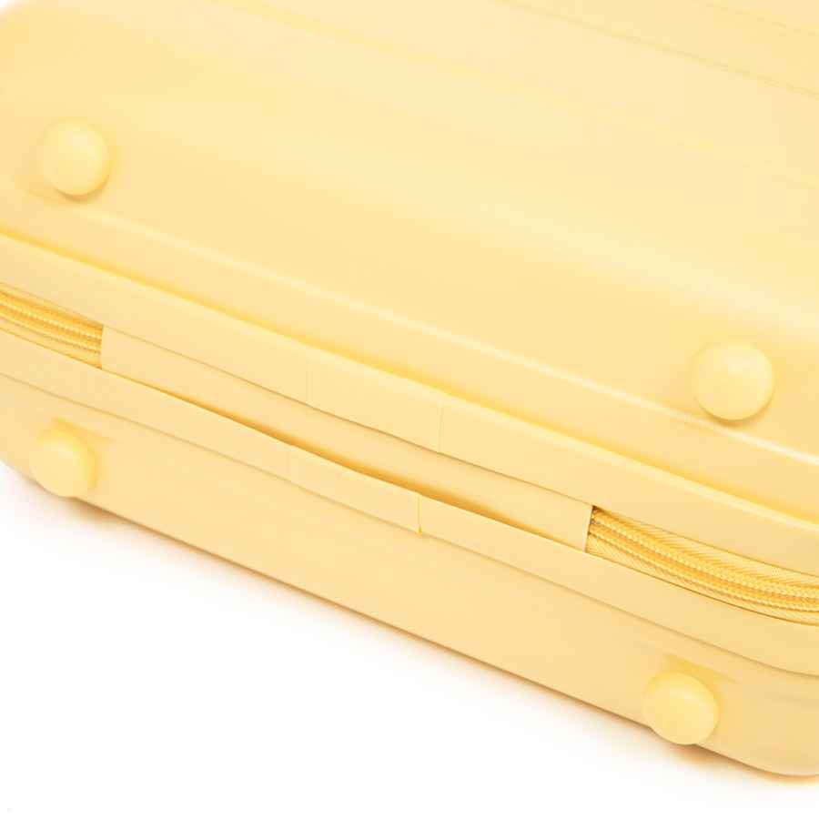 Bottom view of yellow ABS spinner luggage with rounded feet and durable exterior, showcasing its compact and lightweight design.
