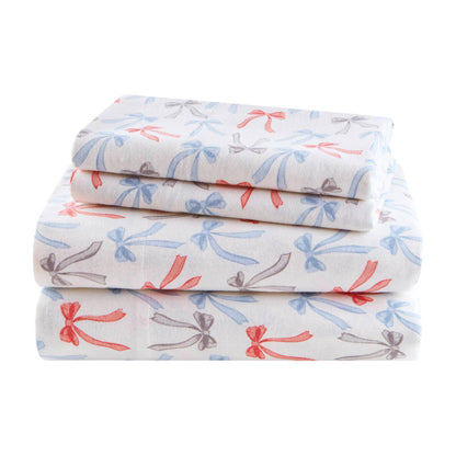 Folded Happy Bows Twin XL Cotton Flannel Sheet Set featuring red, blue, and gray bows, soft texture and machine washable for easy care.
