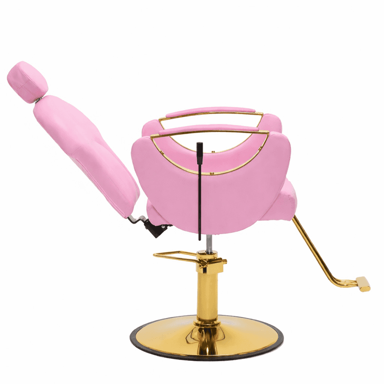 A pink barber chair with a gold metal base, foot pedal, and trim, shown on a plain white background.