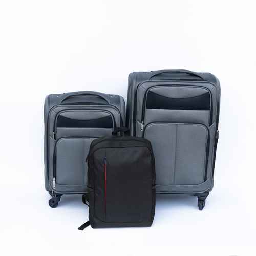 Set of gray suitcases and a black backpack on a white background