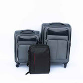 Set of gray suitcases and a black backpack on a white background