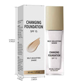 A 30 mL bottle and matching box of Changing Foundation SPF 15 Self-Adjusting Shade, shown on a white background with dimension annotations. The packaging is white with black text and a beige foundation smear graphic, and the bottle has a metallic gold cap and a clear glass base.