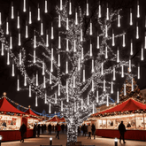 Large tree over a Christmas market lit with white meteor shower lights