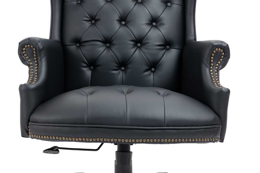Black leather armchair with tufted backrest and decorative nailhead trim on a white background