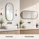 Bathroom vanity setup with oval mirrors, lights, and plants on a neutral background.