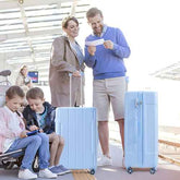 Family with children at an airport, preparing for a trip with blue suitcases.
