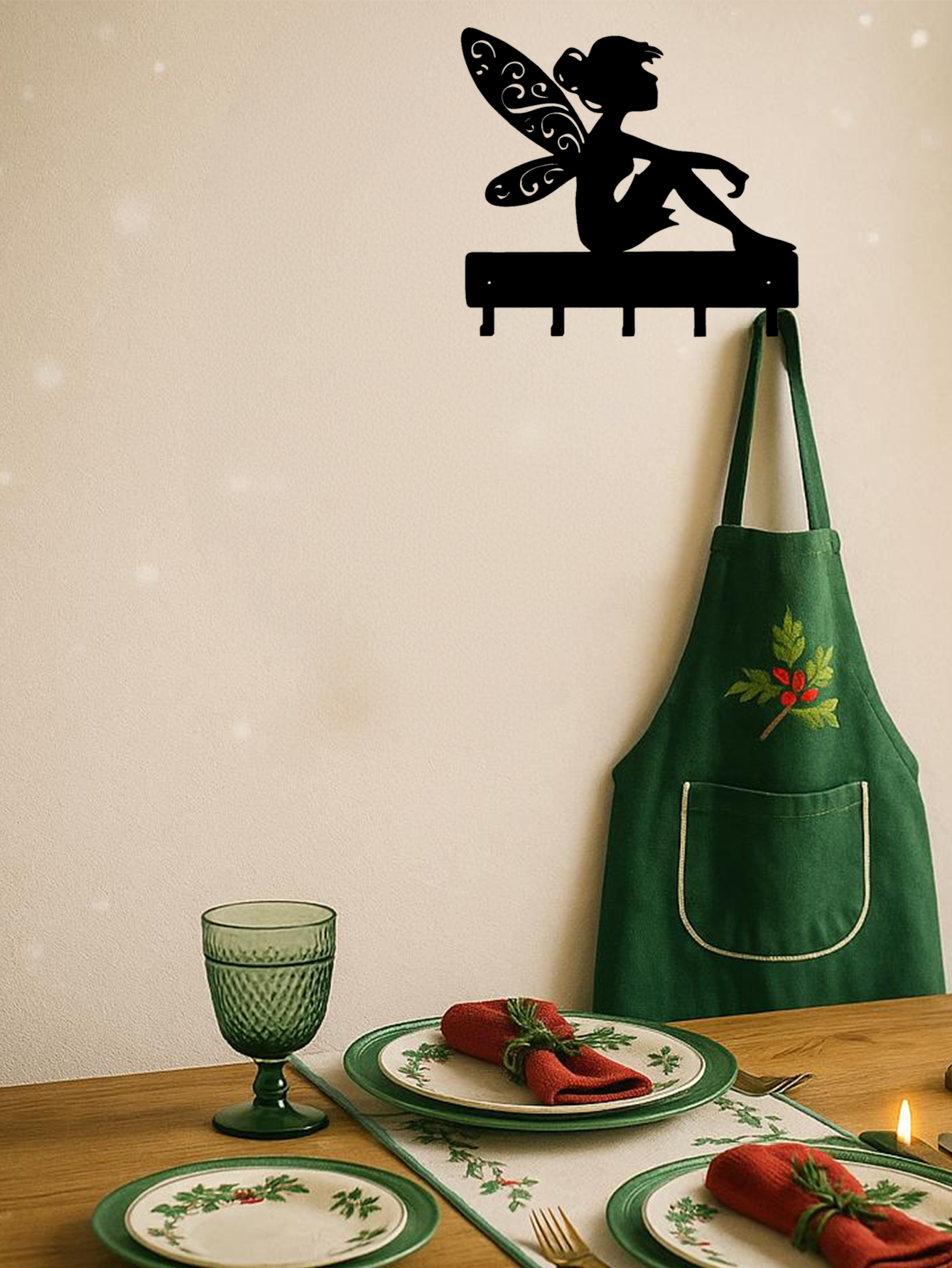 Fantasy wall hook key holder with fairy design used in a dining area to hang a green apron. Adds whimsical charm to kitchen wall decor.