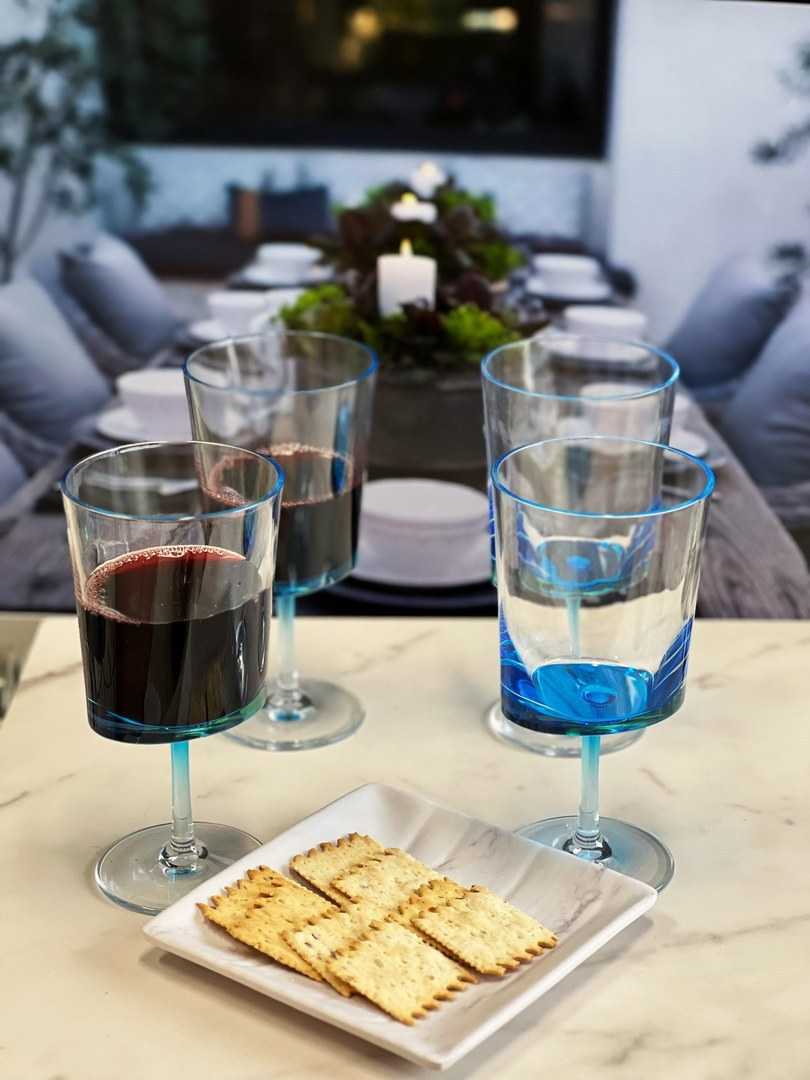 Durable BPA-free blue acrylic wine glasses from LeadingWare set of 4, shown in an elegant outdoor dining setup with red and white wine.