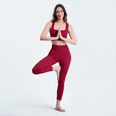 Woman in red yoga outfit posing on a white background
