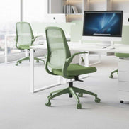 Green office chair in a modern office setting with white desks and computer monitors.