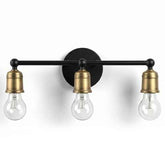 Three-light wall sconce with black and brass finish on a white background