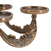 Close-up of a bronze-toned metal candelabra with textured, hammered details and circular candle cups, shown on a plain white background.