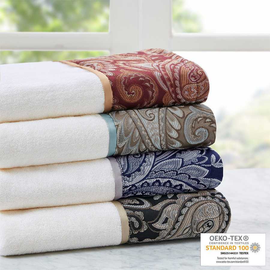 Stacked jacquard bath towels with intricate patterns in various colors