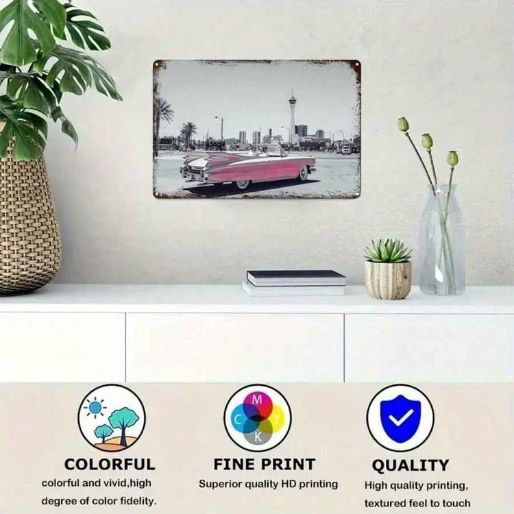 A framed wall art print showing a vintage red car on a city street, displayed above a white console table with a plant, books, and a vase. Three circular icons at the bottom highlight colorful print, fine print quality, and overall quality.