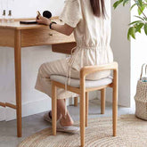 Person sitting at a wooden desk in a home office setting