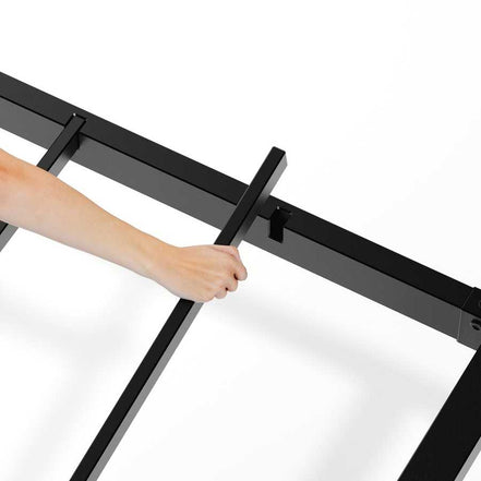 Easy assembly of king floating bed frame with LED lights, showing hand inserting support bar into black metal frame.