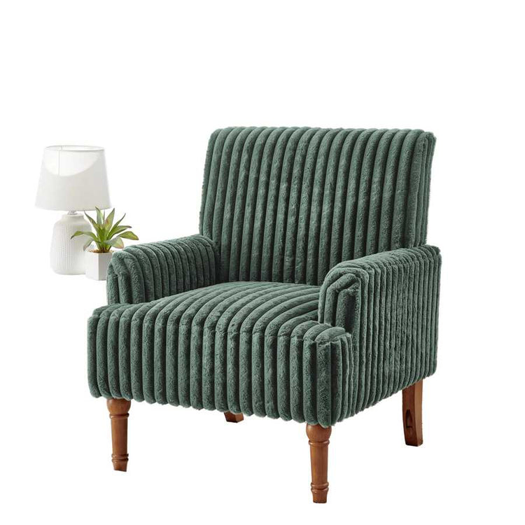Green ribbed armchair in a room with large windows and a white rug.