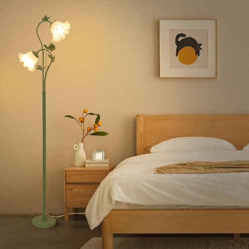 Bedroom with wooden bed, floor lamp, and wall art