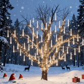 Tree in a snowy forest lit with meteor shower lights and reindeer