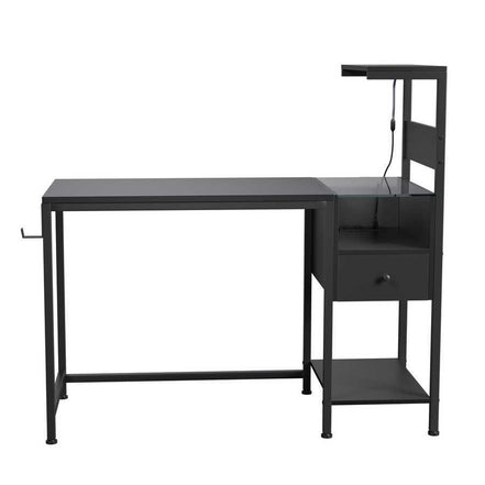 Minimalist black computer desk with built-in power outlet, USB ports, drawer, and reversible shelving for home office use.