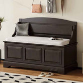 Dark wooden storage bench with cushioned top in a room setting.