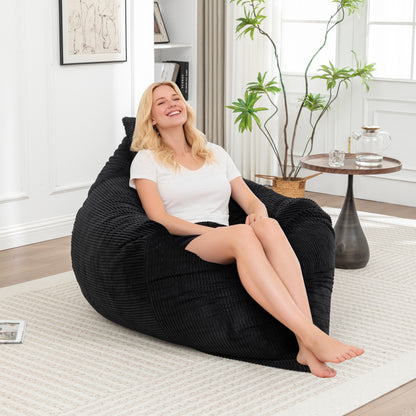 Corduroy Bean Bag Chair - Lounger for Adults & Kids in black, shown in upright position with a woman sitting comfortably in a modern living room.