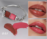 A silver-toned lipstick-shaped bracelet shown on the left, with two close-up lip swatches on the right demonstrating the glossy nude-pink lip color. Two lipstick smears and the shade number 04