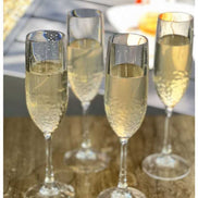 Four unbreakable plastic champagne flutes filled with champagne, ideal for parties and gatherings with a modern touch.