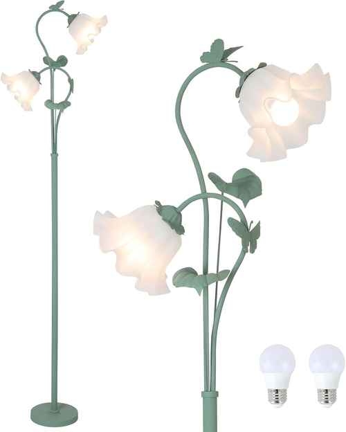 A green metal floor lamp designed like a flowering vine with three glowing frosted glass flower shades. Two bulb bulbs are shown separately at the bottom right against a plain white background.