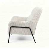 A modern upholstered armchair with a textured vertical stripe pattern in off-white and gray, supported by a sleek black metal frame, shown from a side profile on a white background.