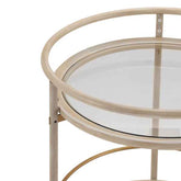 Round glass table with beige metal frame on a white background