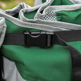 Close-up of a green bag with gray straps and a black buckle.