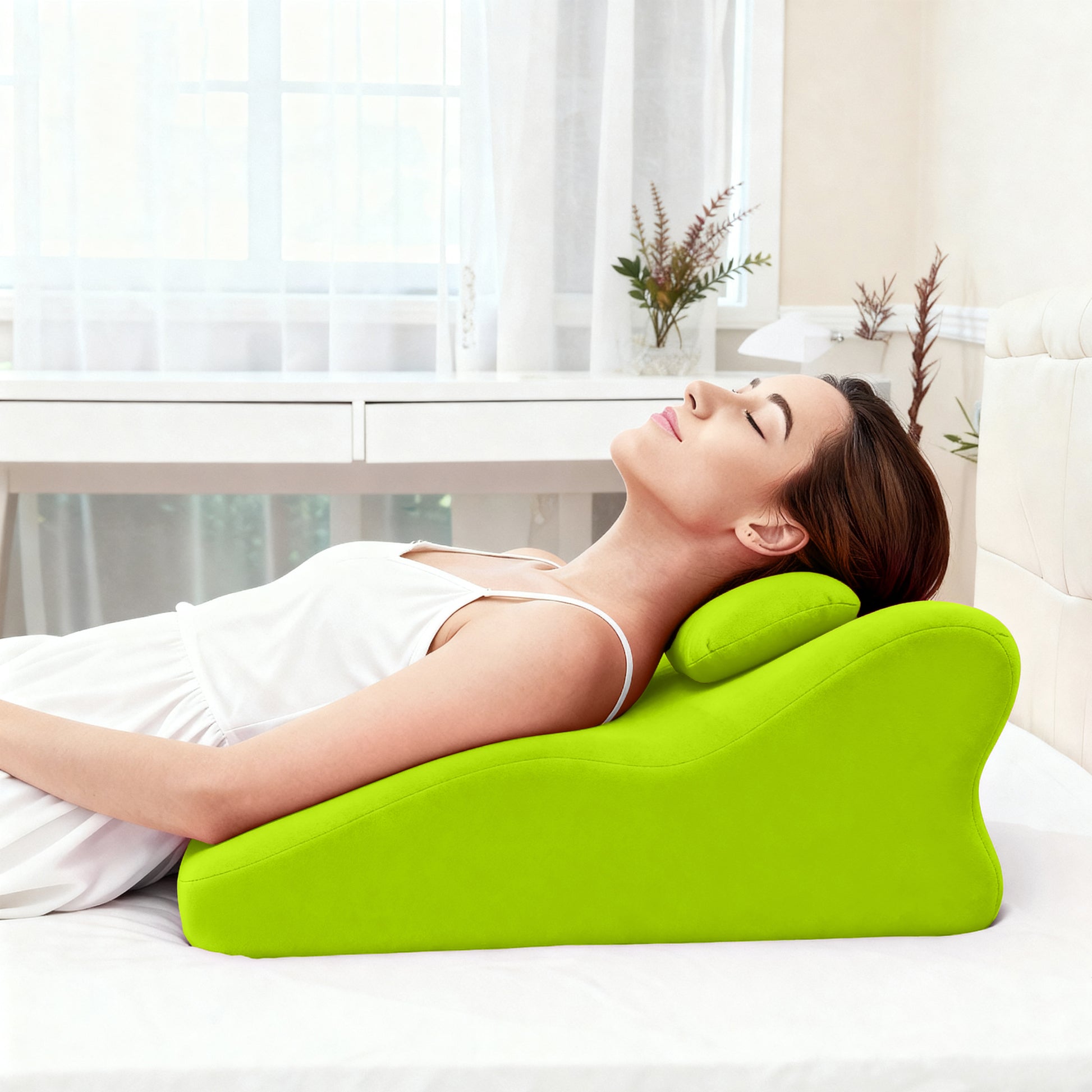 Woman reclining on Ergonomic Spinal Posture Support Pillow - Memory Foam, demonstrating its use for neck and upper back relaxation.