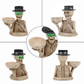 Four views of a decorative skeleton candle holder on a white background, with a circular inset showing a close-up of the glowing green eyes and black top hat. The skeleton holds a beige bowl and is dressed in a black top hat with a silver band.