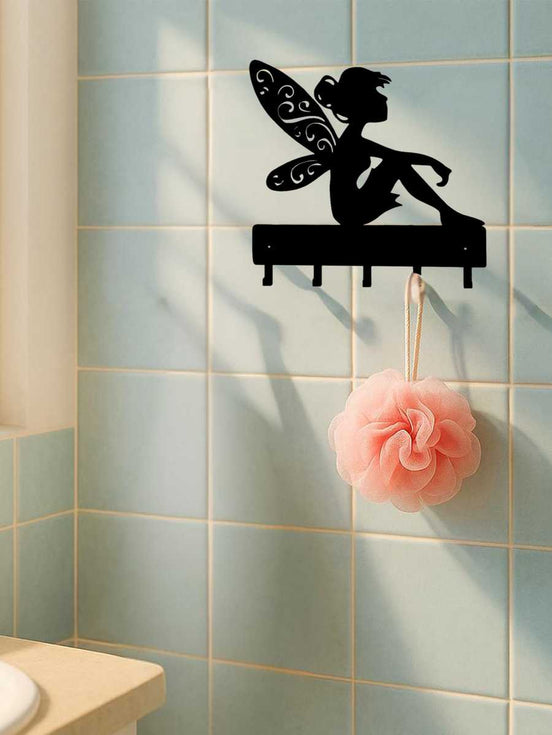 Iron fantasy wall hook key holder with fairy design on bathroom tiles, used to hang a pink bath sponge. Stylish and functional wall decor.