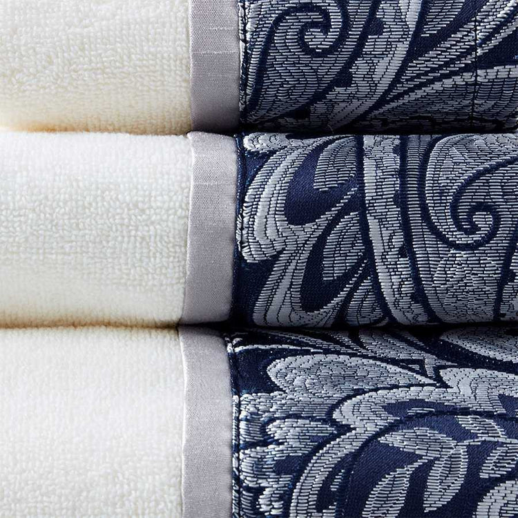 Close-up of white towels with navy and black paisley jacquard borders