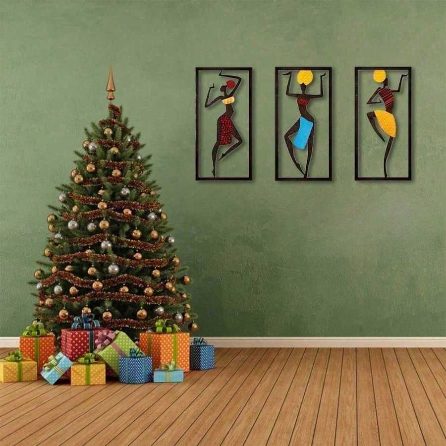 Bohemian Macrame Wall Hanging with African dancer motifs on a green wall beside a decorated Christmas tree and wrapped gifts. Festive home decor accent.