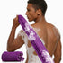 Man with a purple mesh body scrubber on a white background