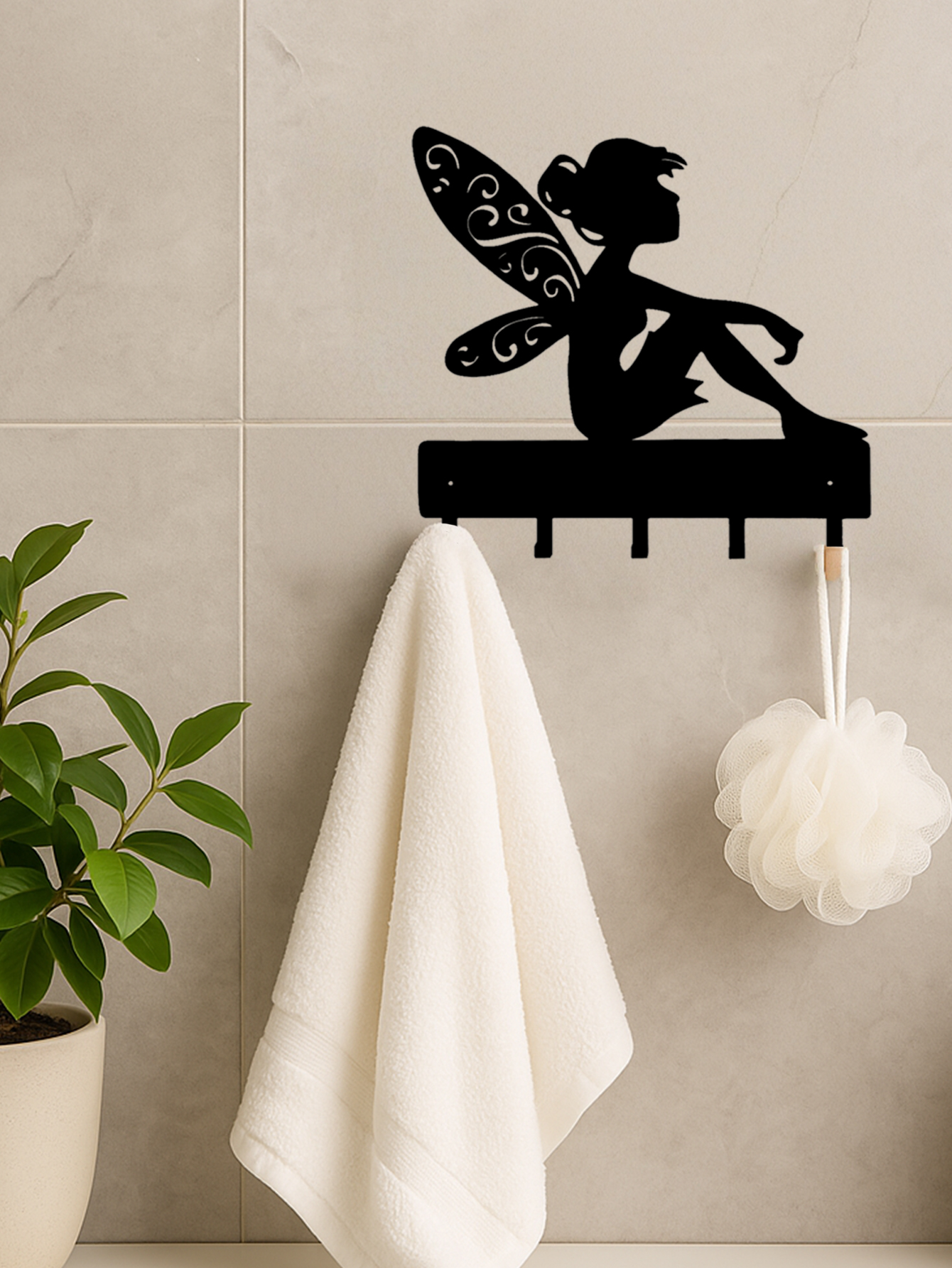 Black iron fantasy wall hook key holder with fairy silhouette on a tiled wall, holding a towel and bath sponge. Perfect for bathroom storage.