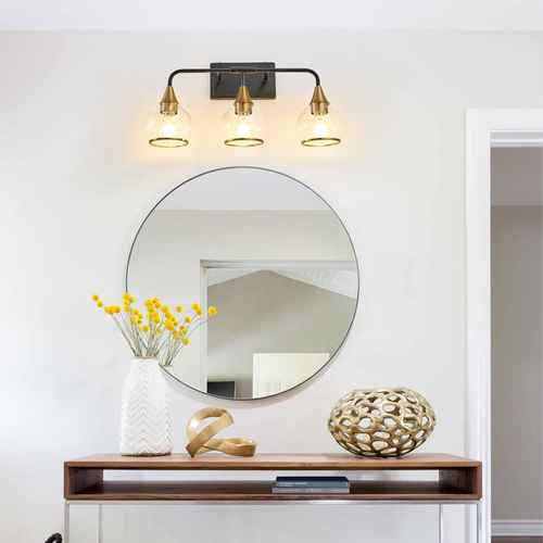 Round mirror on a wooden console table with decorative items and wall lights.
