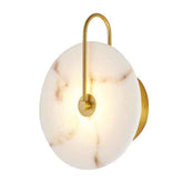 A modern wall sconce light fixture featuring a round white marble shade with subtle brown veining, a curved gold metal U-shaped arm, and a circular gold wall mount, shown against a plain white background.