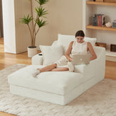 Woman using a laptop on a white lounge chair in a modern living room.