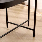 Close-up of a black metal chair leg on a wooden floor