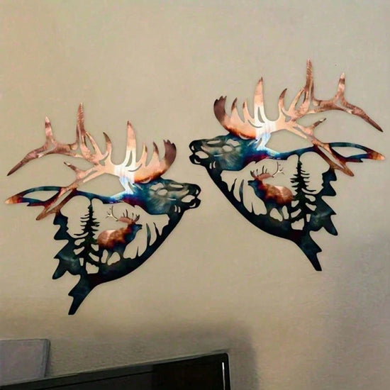 Metal wall art of deer heads with antlers on a plain wall.