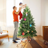 Man decorating a 4 ft green Christmas tree at home